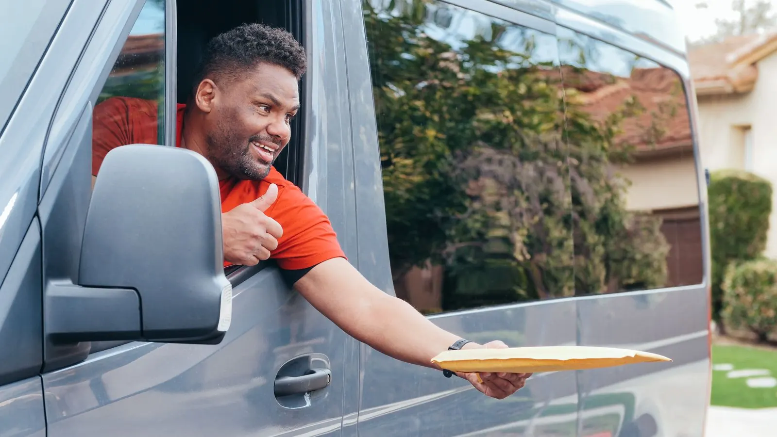 Driver handing a document envelope from the van