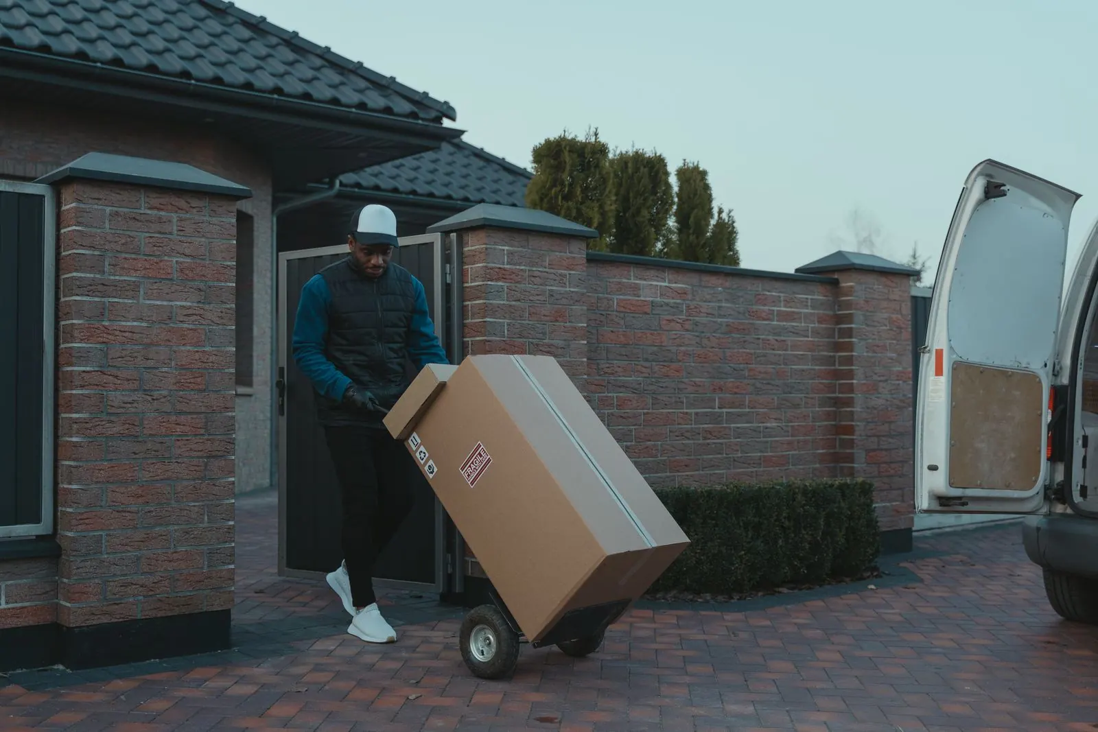 Courier in navy uniform unloading parcels from a van